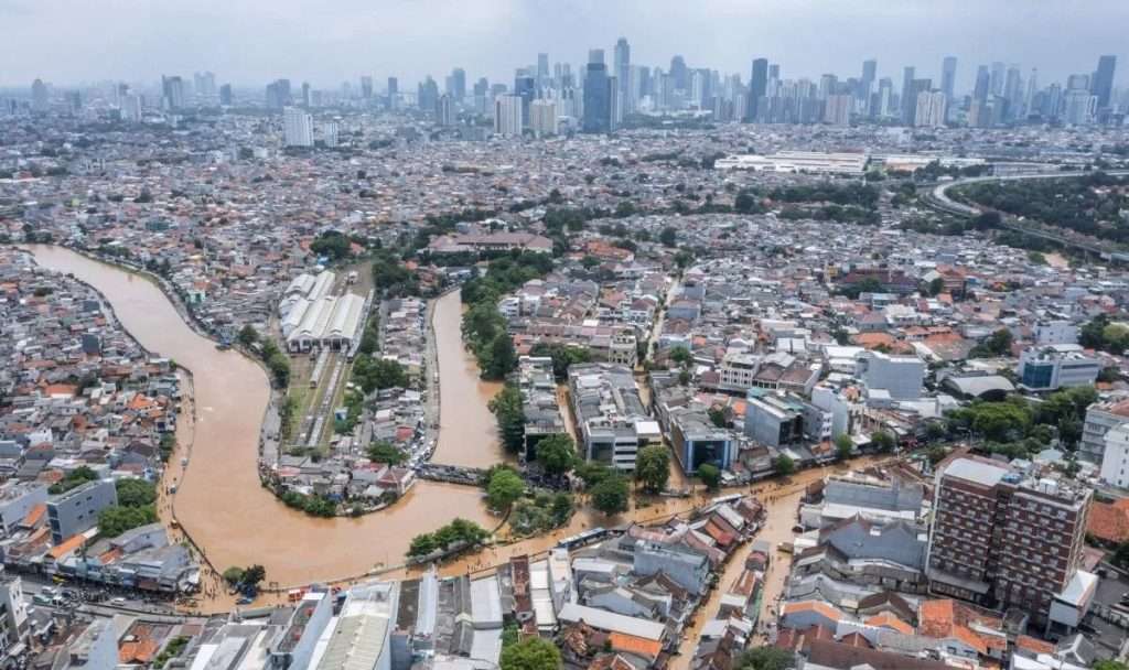 Foto udara luapan Sungai Ciliwung saat banjir Jakarta Maret 2025, menggenangi permukiman dan infrastruktur di sekitarnya.