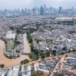 Foto udara luapan Sungai Ciliwung saat banjir Jakarta Maret 2025, menggenangi permukiman dan infrastruktur di sekitarnya.